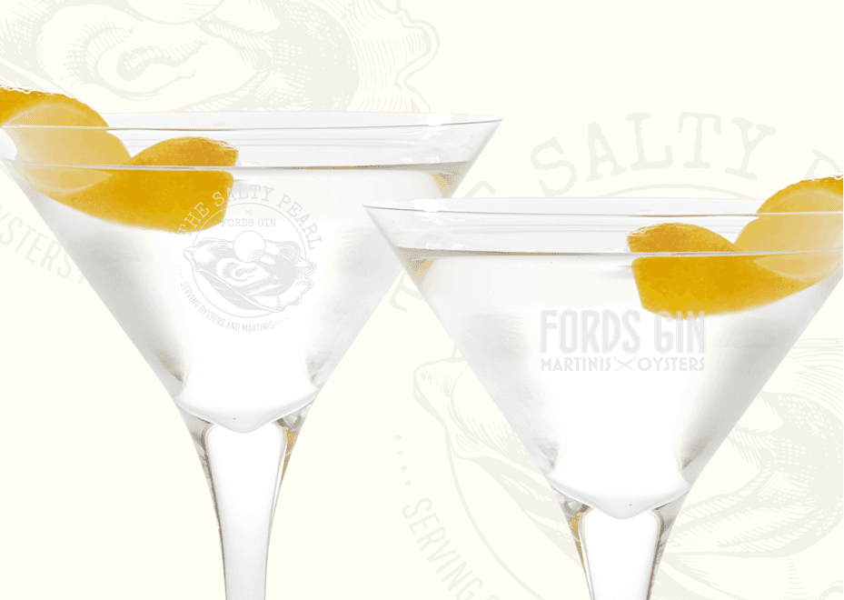 Branded martini glasses with etched Ford’s Gin logo and Salty Pearl emblem, shown with lemon twist garnish