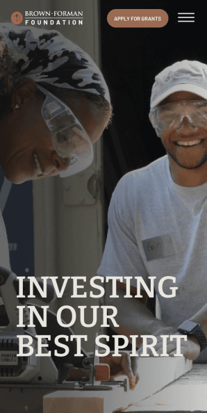 Mobile homepage hero with volunteers and headline Investing In Our Best Spirit