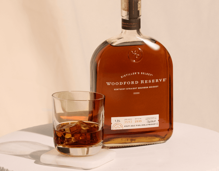 Woodford Reserve bourbon bottle with glass of whiskey in elegant product photography