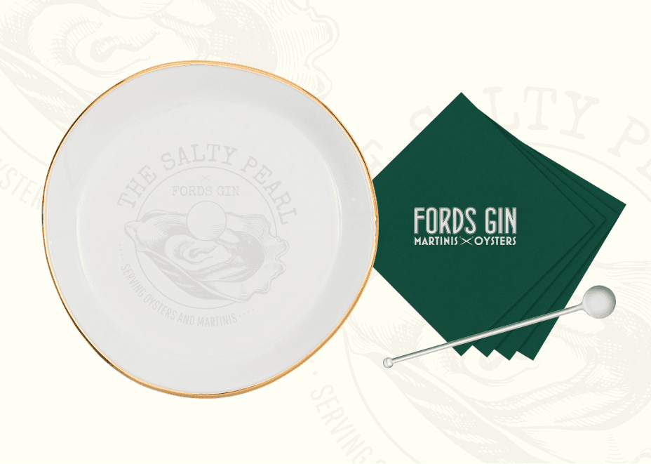 Custom branded oyster serving plate with embossed Salty Pearl logo and branded green cocktail napkin