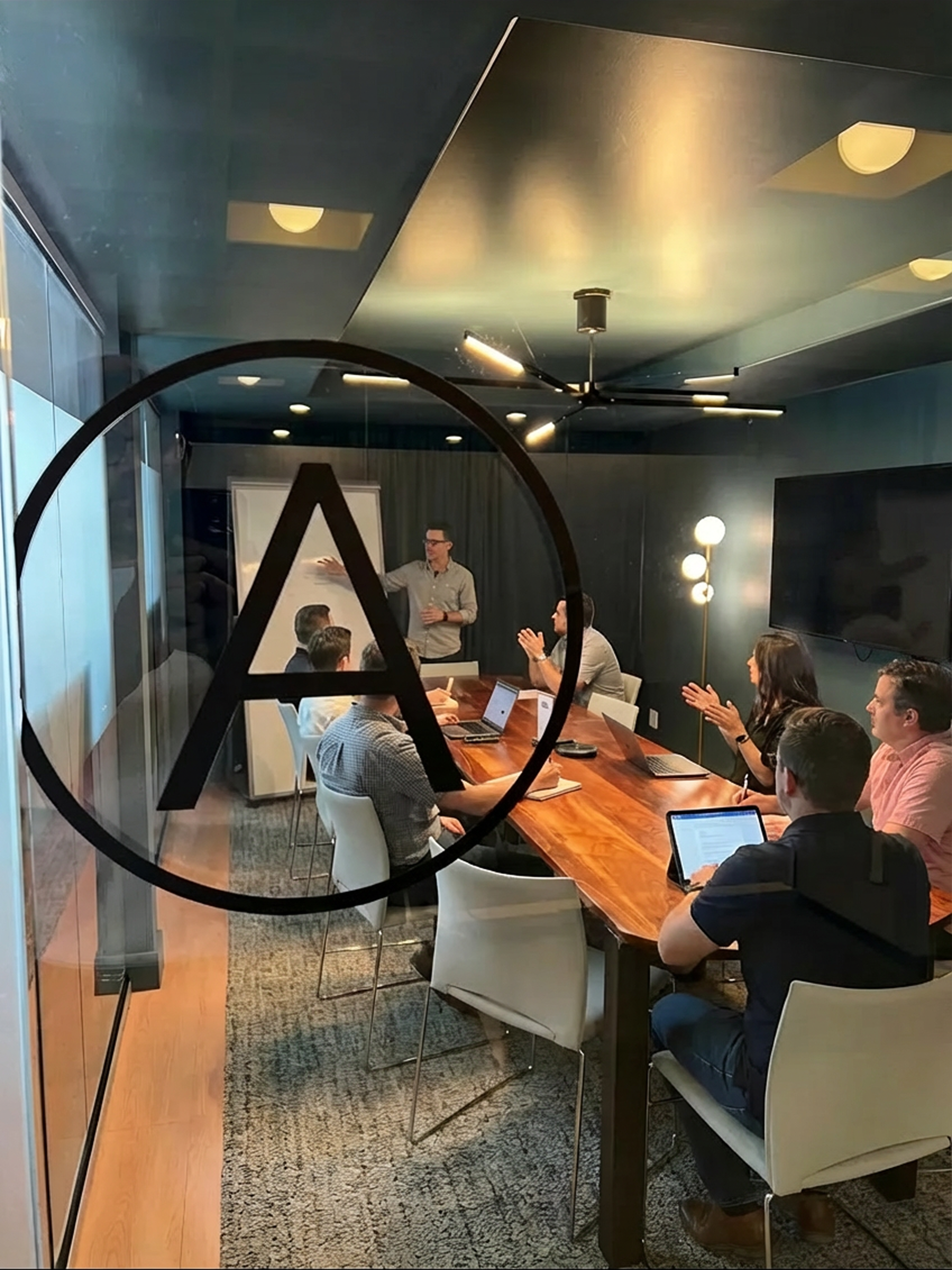 Conference room meeting visible through glass wall with Prolific logo