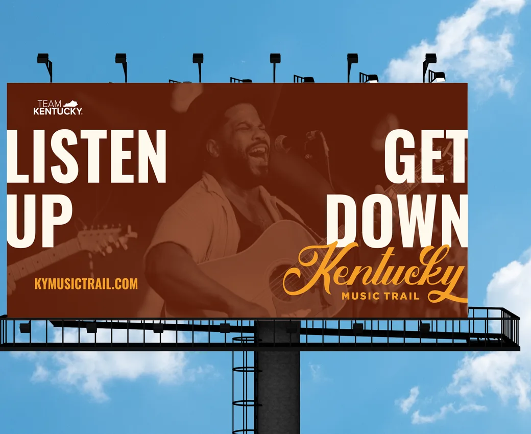 A Kentucky Music Trail billboard against a blue sky: “Listen up. Get down.”